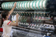 Traditional silk factory. Woman working on silk spinning machine. Dalat. Vietnam.