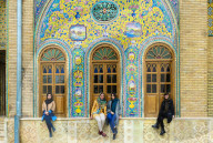 Group of young Iranian women seated in front of ceramic tiles, Golestan Palace, Tehran, Islamic Republic of Iran