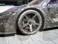 Recycle Art. Auto und Motorradteile ,Schrauben und Zahnraederzusammengeschweist . Bild : Ferrari Sportwagen 