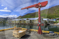 Fishing crates and equipment on quay, mountains and town, Siglufjordur, (Siglufjorour), stunning Summer weather, North Iceland