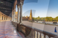 Sunrise on the old tower seen from colonnade of the semi-circular portico, Plaza de Espana, Seville, Andalusia,Spain