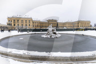Frozen water of Naiad Fountain and snow around Schonbrunn Palace, Vienna, Austria