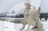 Mythological statue in the snow covered Belvedere Garten, gardens of castle housing an art museum, Vienna, Austria