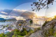 Couple embracing and holding enjoying the view of Alesund at sunset from Byrampen viewpoint, More og Romsdal county, Norway