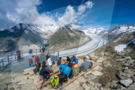 People admiring the majestic Aletsch Glacier from terrace at Eggishorn viewpoint, Bernese Alps, canton of Valais, Switzerland
