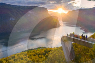 People admiring sunset from Stegastein viewpoint platform above the fjord, aerial view, Aurlandsfjord, Sogn og Fjordane county, Norway