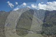 View of the mountains near the Gergeti Holy Trinity Church by the river Chkheri, under Mount Kazbegi at an elevation of 2170 meters in the Caucasus, Georgia