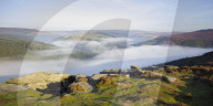 Early morning fog lingering above the Ladybower reservoir in the valley below Bamford Edge