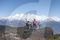 Mountain biking in the Himalayas with views of the Langtang mountain range in the distance