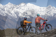 Mountain biking in the Himalayas with views of the Langtang mountain range in the distance