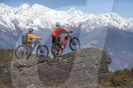 Mountain biking in the Himalayas with views of the Langtang mountain range in the distance