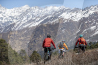 Mountain biking in the Himalayas with views of the Langtang mountain range in the distance