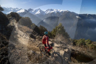 A mountain biker takes a rest on an Enduro style single track trail in the Nepal Himalayas near the Langtang region