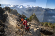 Mountain bikers take a rest on an Enduro style single track trail in the Nepal Himalayas near the Langtang region