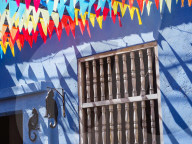 Colorful flags and a blue building with a cat sign, Getsemani barrio, Cartagena, Colombia, South America