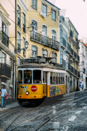 Traditional yellow eletric tram in a narrow street in Alfama, Lisbon, Portugal