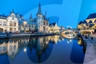 Graslei quay in the historic city center of Ghent, Belgium is mirrored in the River Lys during blue hour.