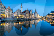 Graslei quay in the historic city center of Ghent, Belgium is mirrored in the River Lys during blue hour.