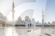 The domes and minarets of Abu Dhabi's Grand Mosque viewed across the large marble tiled central courtyard.