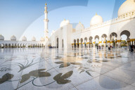 The domes and minarets of Abu Dhabi's Grand Mosque viewed across the large marble tiled central courtyard.