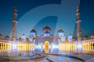 Abu Dhabi's magnificent Grand Mosque lit up during the evening blue hour.