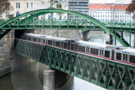 U-Bahn train on Zollamtssteg Arch Bridge with ZollamtsbrÃ¼cke Truss Bridge in Vienna, Austria.