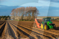 Rural landscape Tractors ploughing and sewing fields in early Spring time at Burnham Overy Norfolk, East Anglia, England UK