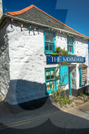 Whitewashed cottage at the picturesque fishing village of Mousehole, Cornwall, UK