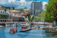 City skyline with canal boats at Pero's Bridge across the Floating Harbour, Harbourside, Bristol, England, United Kingdom