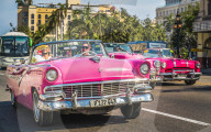 Colourful old American taxi cars driving in Havana, La Habana, Cuba, West Indies, Caribbean, Central America