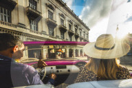 Tourist enjoying classic car ride at sunset in La Habana, Havana, Cuba, West Indies, Caribbean, Central America