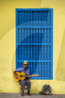 An elderly Cuban sitting on a chair. playing a guitar, Trinidad, Sancti Spiritus Province, Cuba, Central America