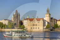 Tourist boat on Vltava River passing the Old Town Bridge Tower and the Old Town Water Tower, Prague, Bohemia, Czech Republic