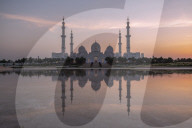 Sheikh Zayed Mosque (also known as the Grand Mosque) reflected in a pool of water at sunset in Abu Dhabi, UAE