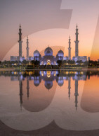 Sheikh Zayed Mosque (also known as the Grand Mosque) reflected in a pool of water at sunset in Abu Dhabi, UAE