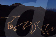 Pass road Stilfser Joch at night with light band of driving cars. Long time exposure