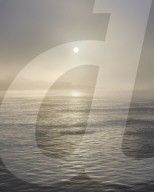 The sun shines through heavy fog on the sea front at Exmouth, Devon, UK