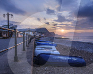 Sunrise looking along the beach at the picturesque seaside town of Sidmouth, Devon, UK