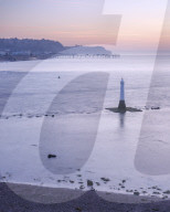 Early morning looking to Teignmouth with the Navigation mark at the entrance to the River Teign, viewed from Shaldon, Devon, UK