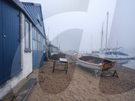 Misty scene with boats on the shoreline near the boatyard and sailmaker on a creek in Exmouth, Devon, UK