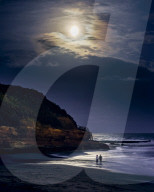 Two ladies paddle whilst watching the full Blood Moon, shortly after an eclipse at Orcombe Point, Exmouth, Devon, UK.