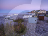 A lilac twilight with boats on the pebbled beach at Budliegh Salterton, Devon, UK