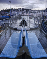 Wet teak decking and benches of the elevated nautical viewpoint for the harbour of Brixham, Devon, UK