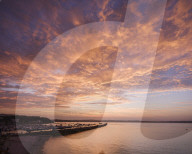 Colourful sunset view of Breakwater Beach and the harbour wall of Brixham, Devon, UK