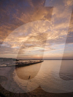 Colourful sunset view of Breakwater Beach and the harbour wall of Brixham, Devon, UK