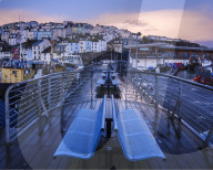 Wet teak decking and benches of the elevated nautical viewpoint for the harbour of Brixham, Devon, UK