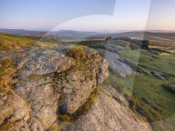 Warm sunlight on the granite summit of Saddle Tor in Dartmoor National Park, Bovey Tracey, Devon UK