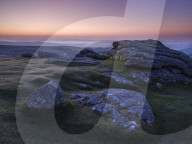 Views over Dartmoor National Park and mist in the Teign Valley seen from summit of Haytor, Bovey Tracey, Devon UK