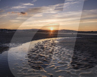 Looking at the setting sun across the Exe estuary towards Starcross from Exmouth, Devon, UK