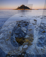 Sunrise with warm light making the granite walls golden at St Michael's Mount in Marazion, Cornwall, UK